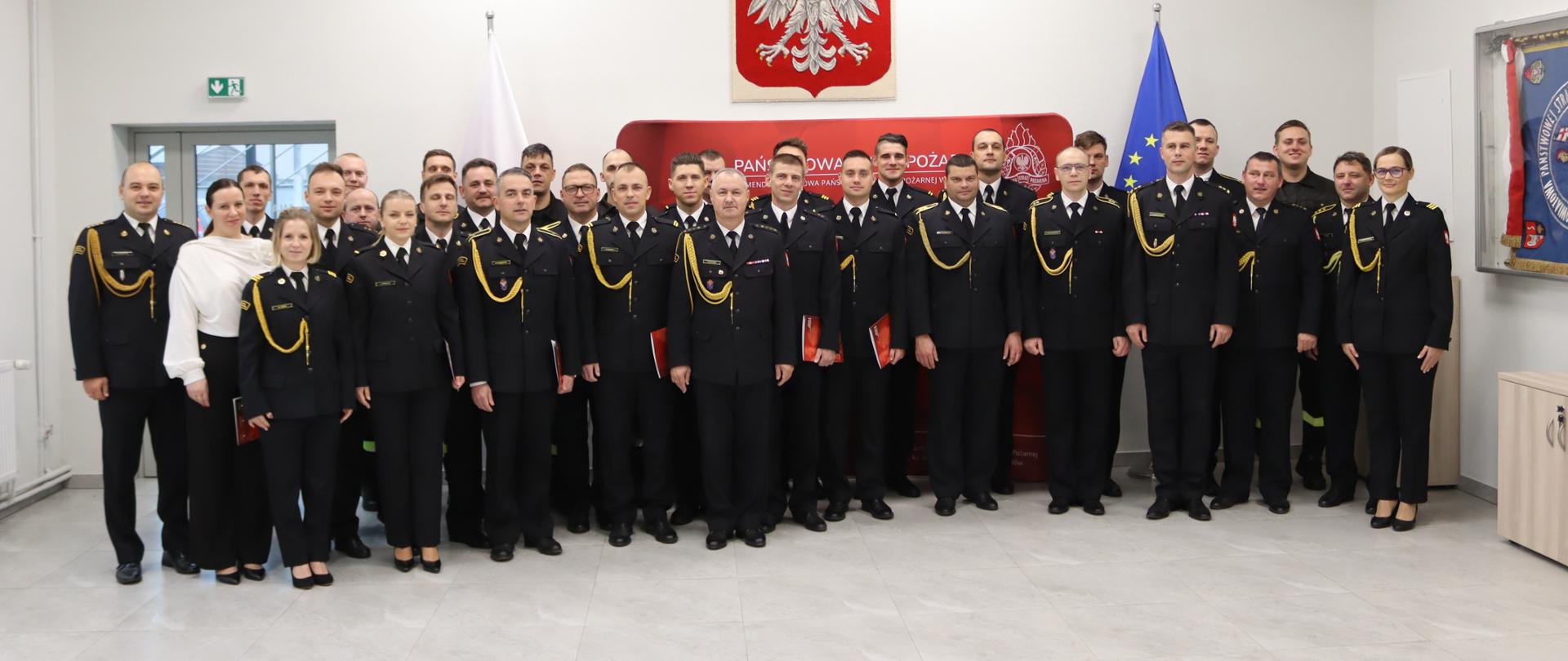 Wspólne zdjęcie w tle flagi państwowe u góry godło 