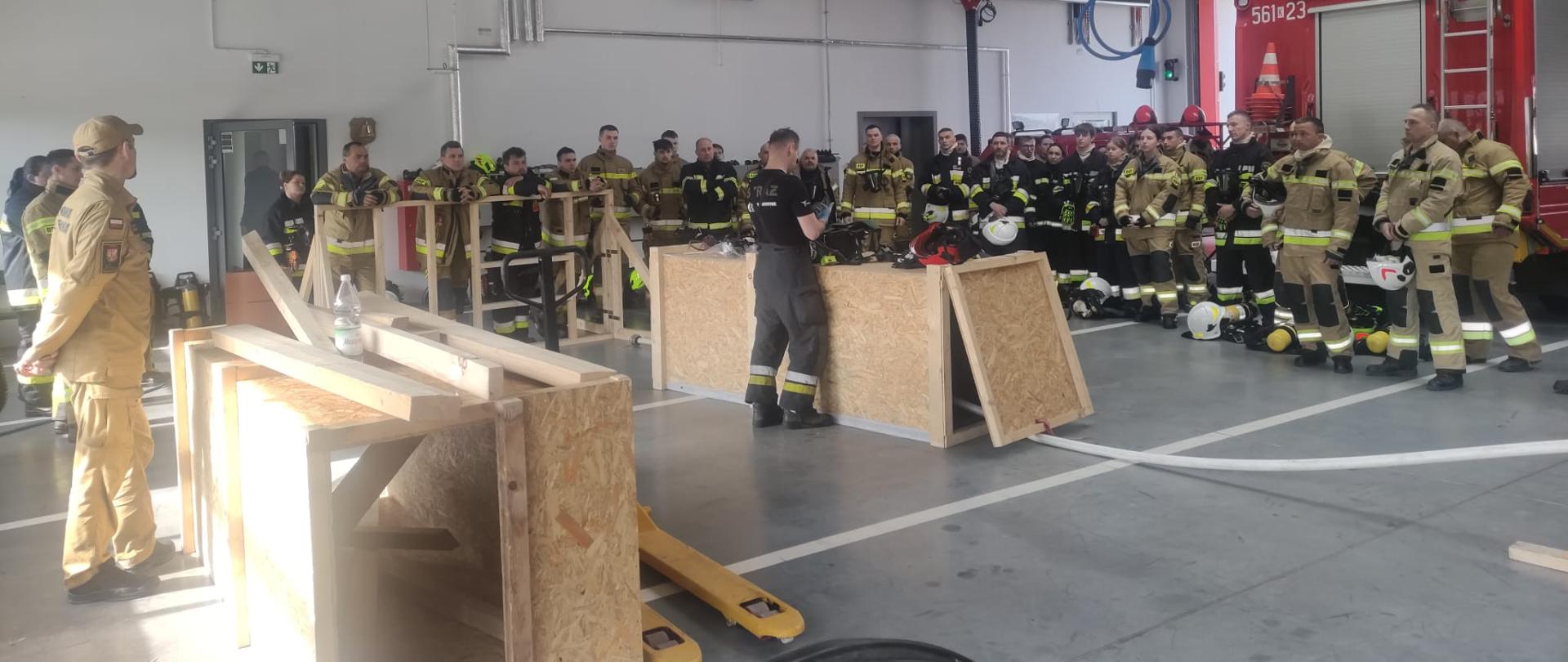 Na zdjęciu grupa szkolonych strażaków OSP zebrana w dwuszeregu na garażu KP PSP w Wieliczce