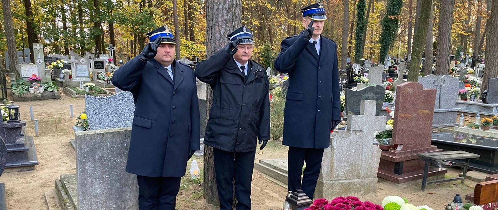 Komendanci Powiatowi wraz z prezesem Związku Ochotniczych Straży Pożarnych w mundurach wyjściowych oddają honory przy grobie zmarłego strażaka
