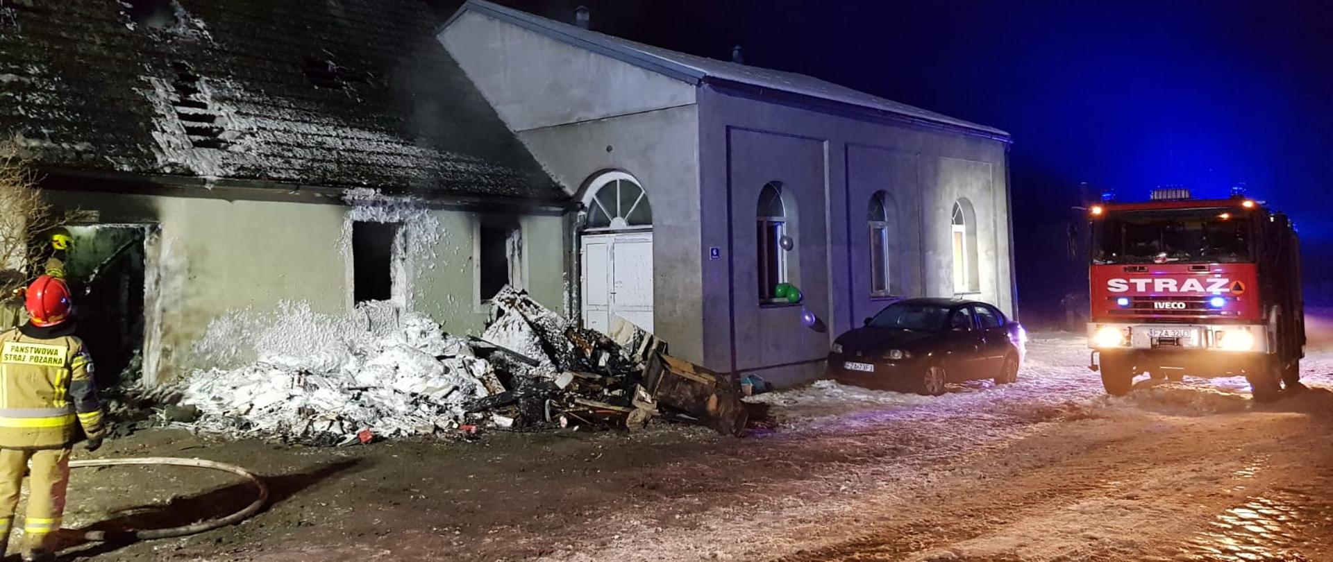 Pożar budynku mieszkalnego jednorodzinnego w miejscowości Chocimek. Strażacy dogaszają i usuwają spalone elementy wyposażenia budynku. 