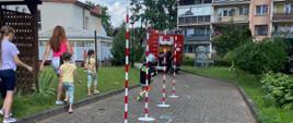 Strażacki tor przeszkód - dziecko biegnie pomiędzy tyczkami.