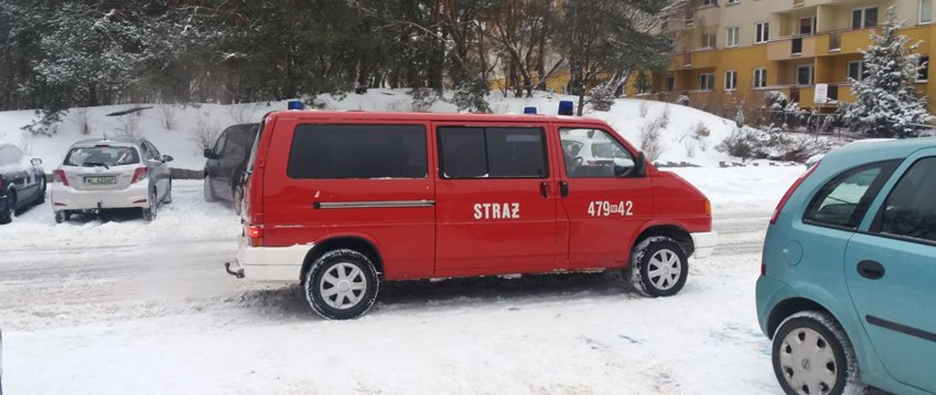  Na zdjęciu samochód czerwony dostawczy z napisem straż na ulicy. 