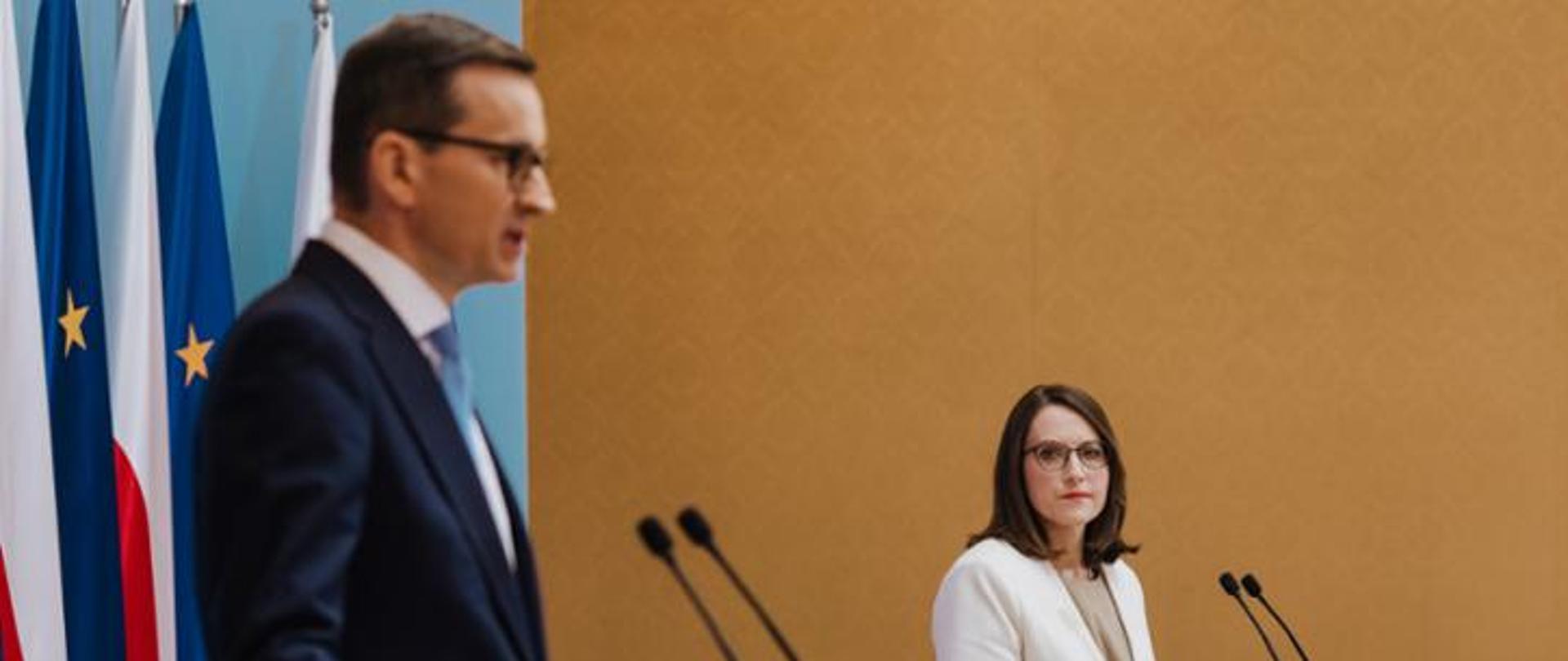 Mężczyzna i kobieta stojący przed mównicami