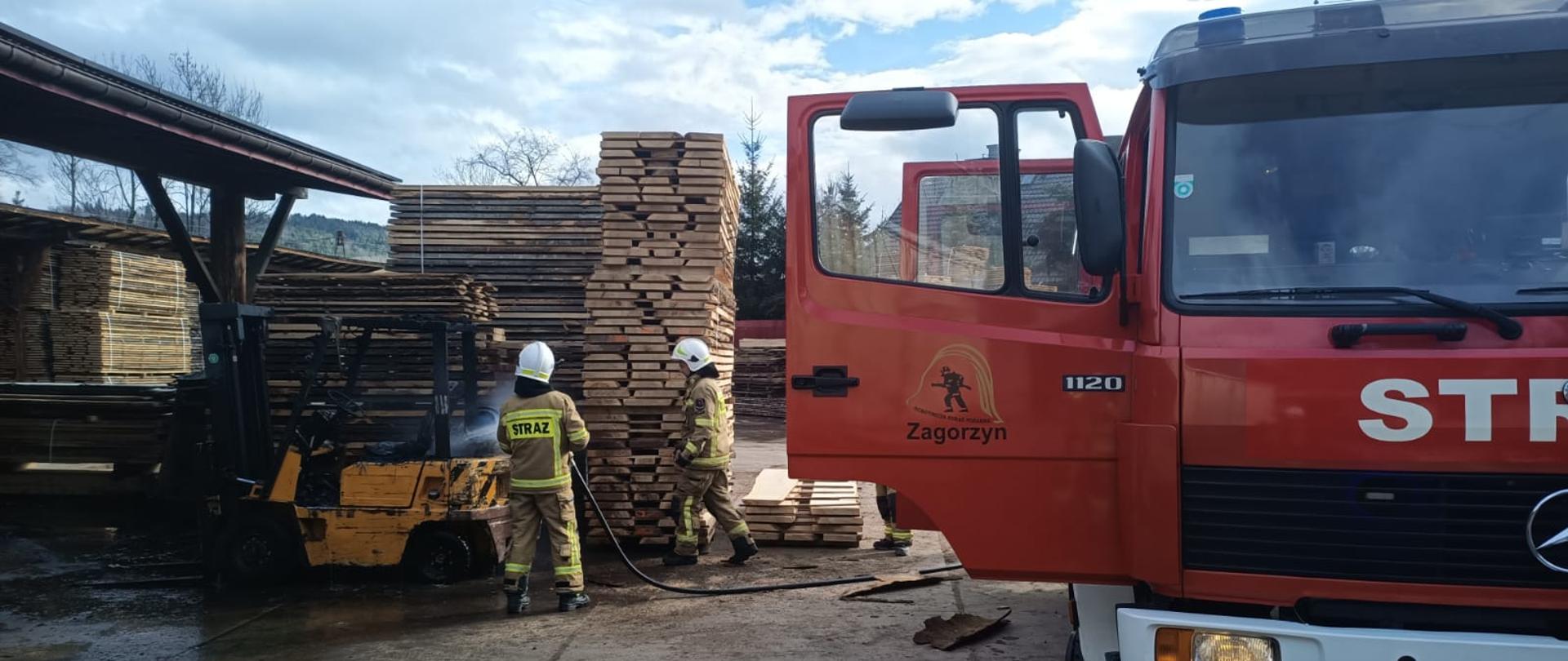 Strażacy chłodzą wózek widłowy