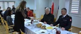 strażacy i zaproszeni goście przy stole wigilijnym