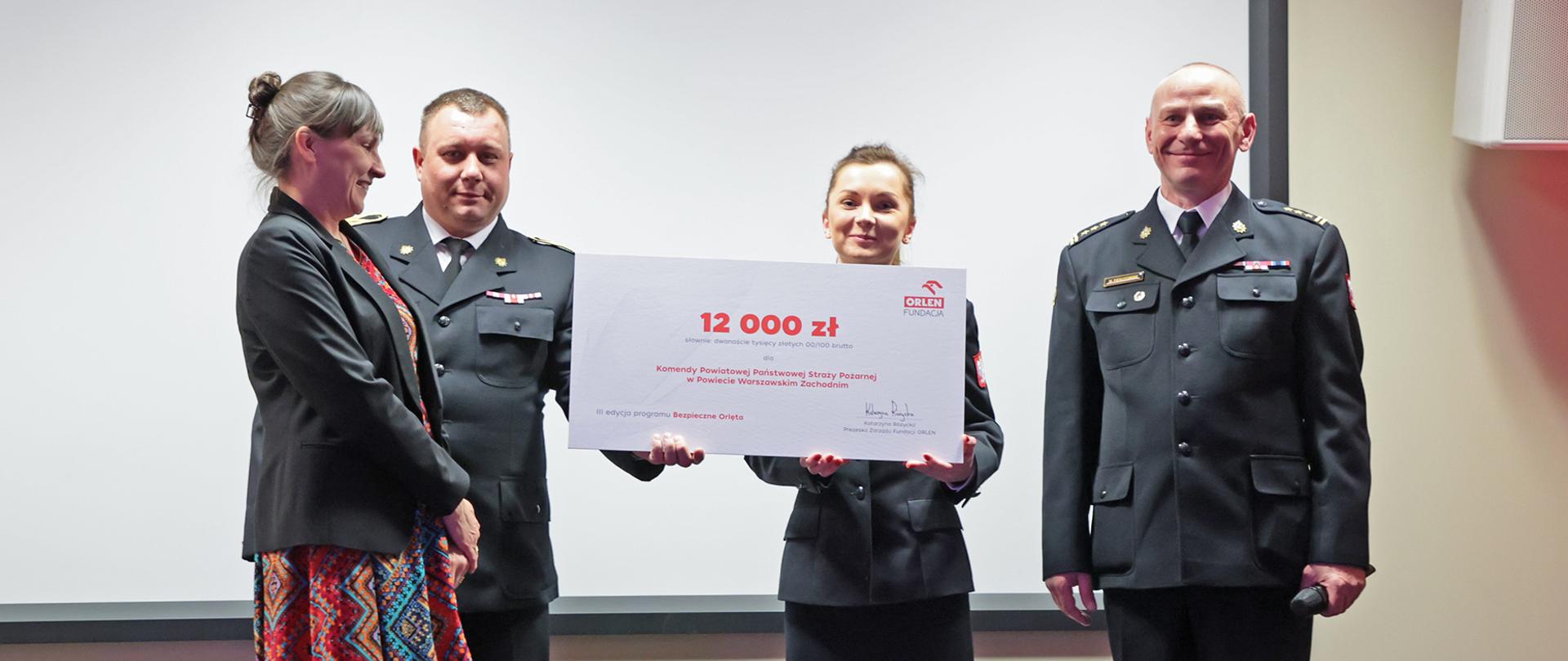 Funkcjonariusze PSP podczas odbierania czeku na zadanie bezpieczne orlęta
