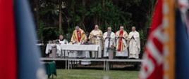 Ołtarz polowy i księża stojący odprawiający mszę 