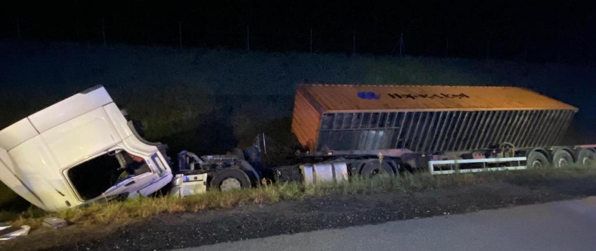 Widok samochodu ciężarowego przewróconego w rowie.