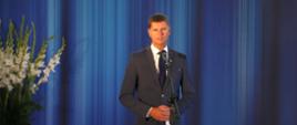 Wiceminister Dariusz Piontkowski gościem Dnia Edukacji Narodowej w Suwałkach, wiceminister Dariusz Piontkowski przemawia, stoi przed mikrofonem.