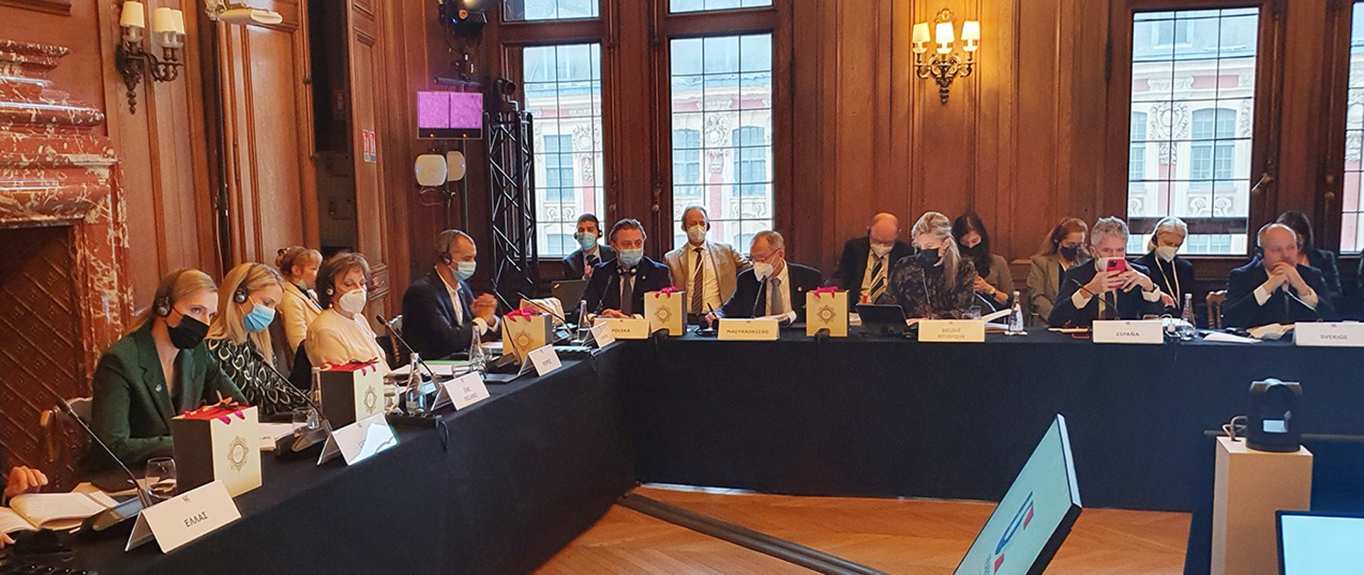 Na zdjęciu widać wiceministra Bartosza Grodeckiego i innych uczestników spotkania siedzących za stołem w trakcie dyskusji.