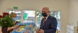 Wojewoda Lubuski przekazuje dyrektor placówki upominek dla dzieci 