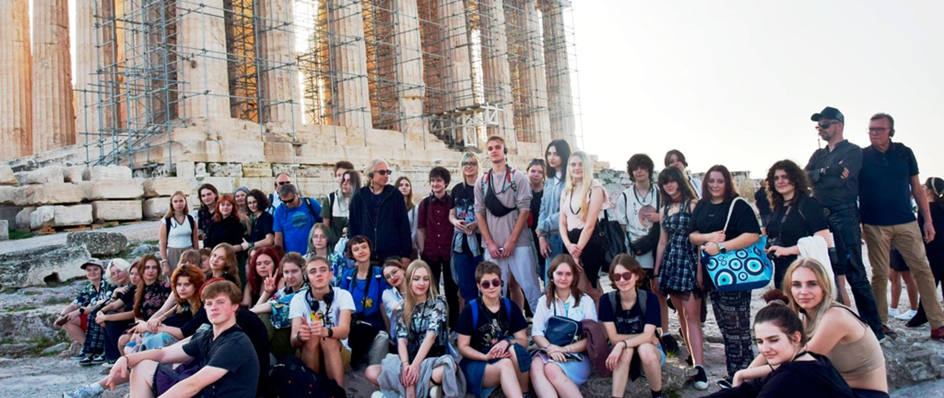 Pod Partenonem grupa uczniów słucha wykładu