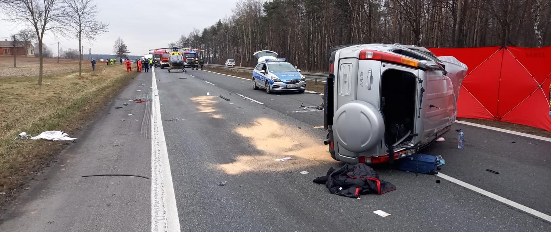 Fotografia przedstawia zniszczony samochód Honda CRV leżący na prawym boku po wypadku.
