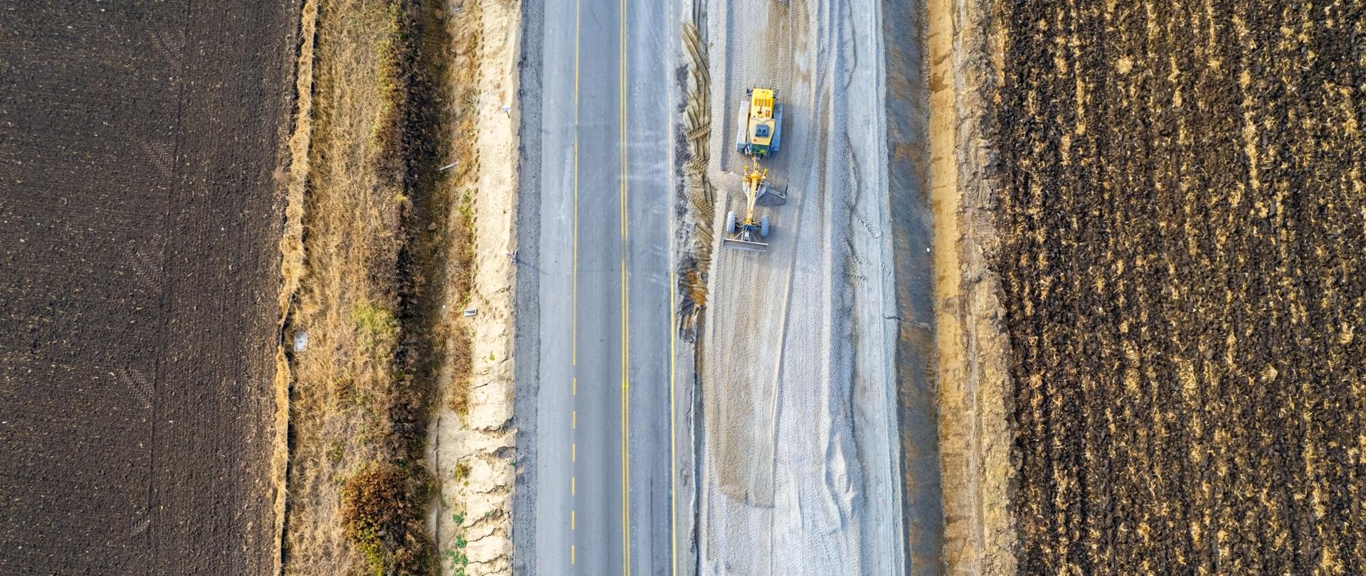 Budowa drogi nr 28 i koparka pracująca na jednym z pasów