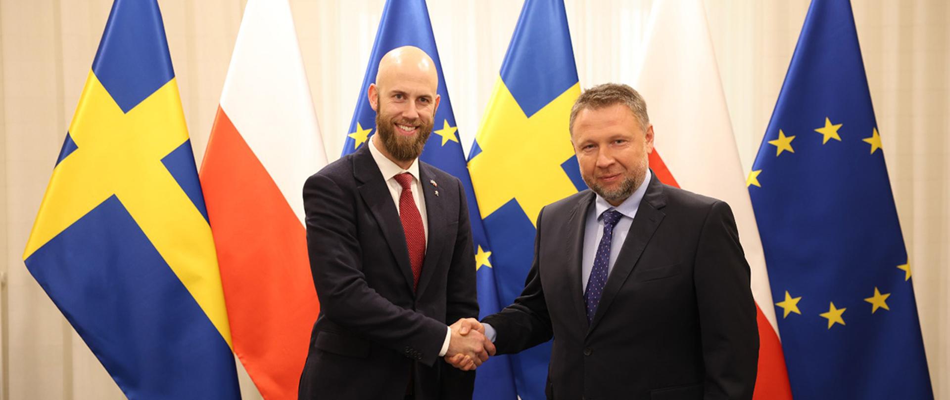 Na zdjęciu minister spraw wewnętrznych i administracji Marcina Kierwińskiego i szwedzki minister ds. obrony cywilnej Carlem-Oskarem Bohlinem witają się na tle flag Polski, Szwecji i Uni Europejskiej.