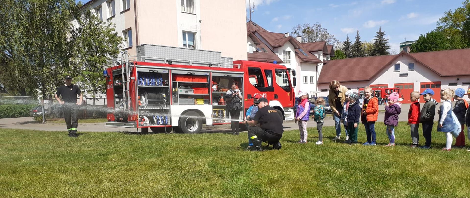 Na zdjęciu widać strażaków oraz dzieci podczas pokazów 