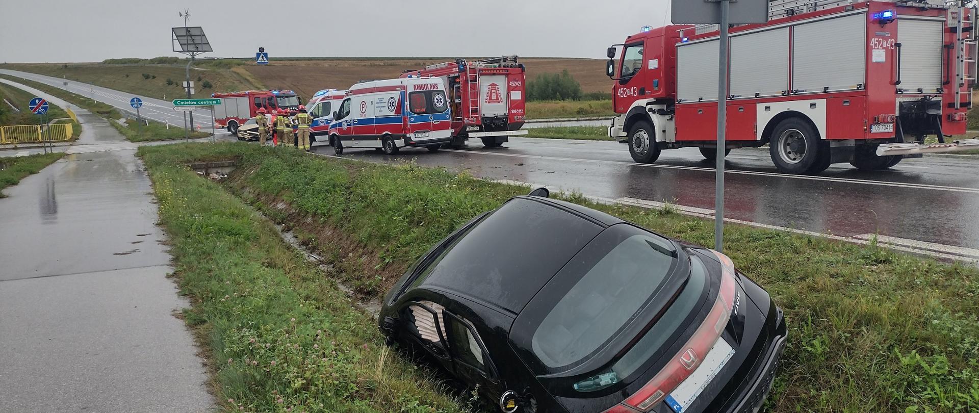 Samochód osobowy w rowie, na drugim planie samochody ratowniczo gaśnicze, oraz karetki pogotowia