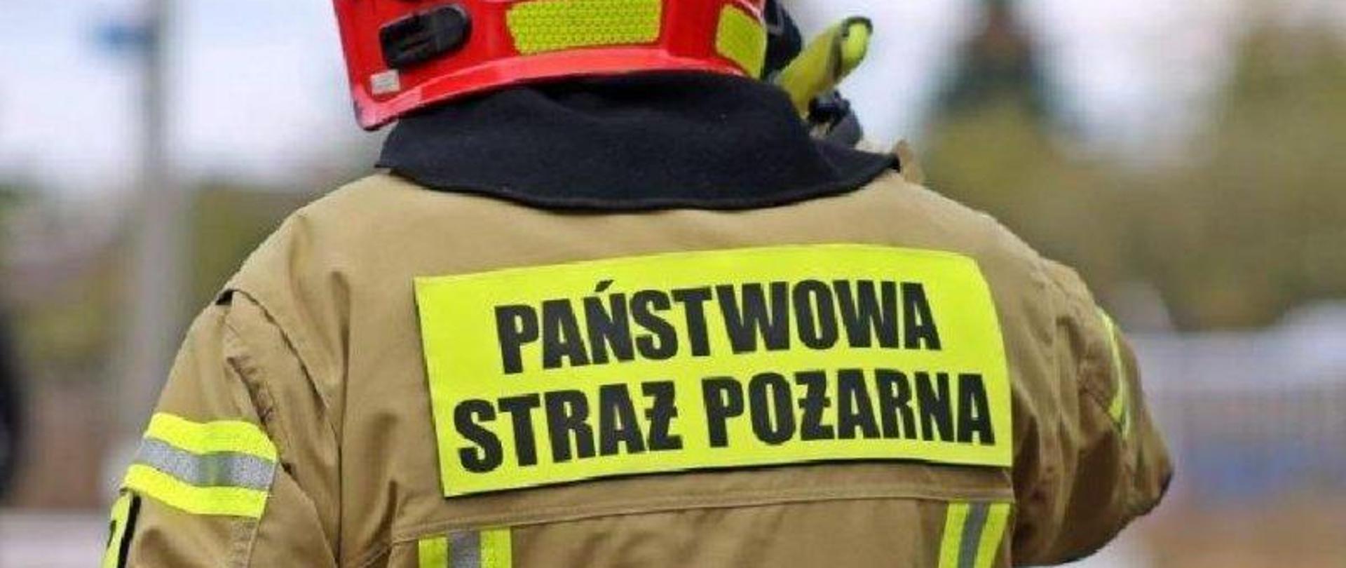 Napis Państwowa Straż Pożarna na plecach strażaka