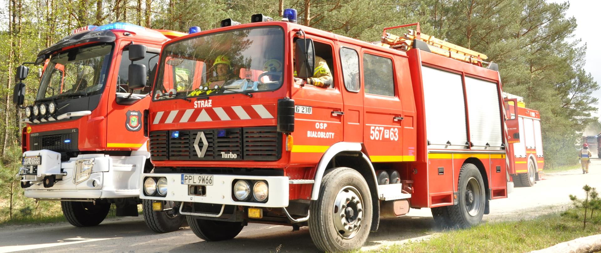 Dwa auta gaśnicze stoją obok siebie na leśnej drodze