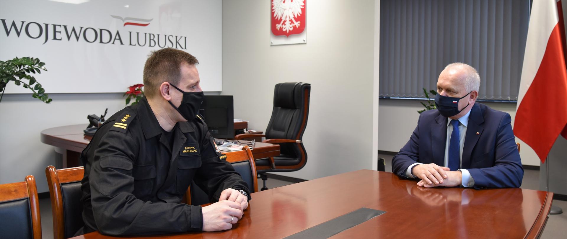 Na zdjęciu widać Lubuskiego Komendanta Wojewódzkiego Państwowej Straży Pożarnej oraz Wojewodę Lubuskiego podczas rozmowy przy stole w siedzibie LUW.