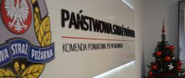 Widoczne logo państwowej straży pożarnej oraz choinka w tle.