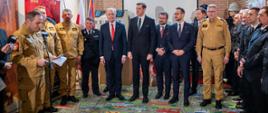 strażacy PSP, druhowie OSP, posłowie oraz przedstawiciele władz samorządowych podczas powitania na uroczystości wręczenie promes, które odbyło się w salce edukacyjnej dla dzieci w budynku KP PSP powiatu łódzkiego wschodniego