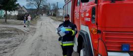 Zdjęcie przedstawia strażaków biorących udział w akcji dystrybucji ulotek dot. szczepień.