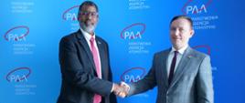 Dyrektor generalny NEA OECD William D. Magwood IV (po lewej) i prezes PAA Andrzej Głowacki (po prawej) wymieniają uściski dłoni podczas spotkania w Warszawie