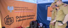 Na zdjęciu widoczny jest namiot Akademii Ochrony LudnoścI oraz funkcjonariusze KP PSP w Ostrowcu Św. w trakcie prowadzenia zajęć z zakresu ochrony ludności i obrony cywilnej oraz postępowania w sytuacjach kryzysowych.