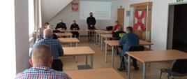 Zdjęcie przedstawia uczestników konsultacji społecznych projektu Ustawy o Ochotniczej Straży Pożarnej zorganizowanych w siedzibie Komendy Powiatowej PSP w Gołdapi