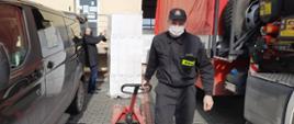 Na zdjęciu rozładunek maseczek chirurgicznych dla gmin