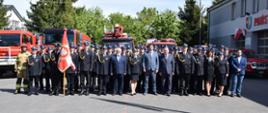 Wszyscy funkcjonariusze, pracownicy oraz goście obecni na uroczystym apelu na zdjęciu grupowym, w tle samochody pożarnicze