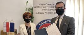 Od lewej stoi nowo powołana PPIS w Lipsku, pani mgr inż. Iwona Pastuszka, obok po prawej MPWIS - dr n. med.Przemysław Rzodkiewicz wręczający dokument z powołaniem