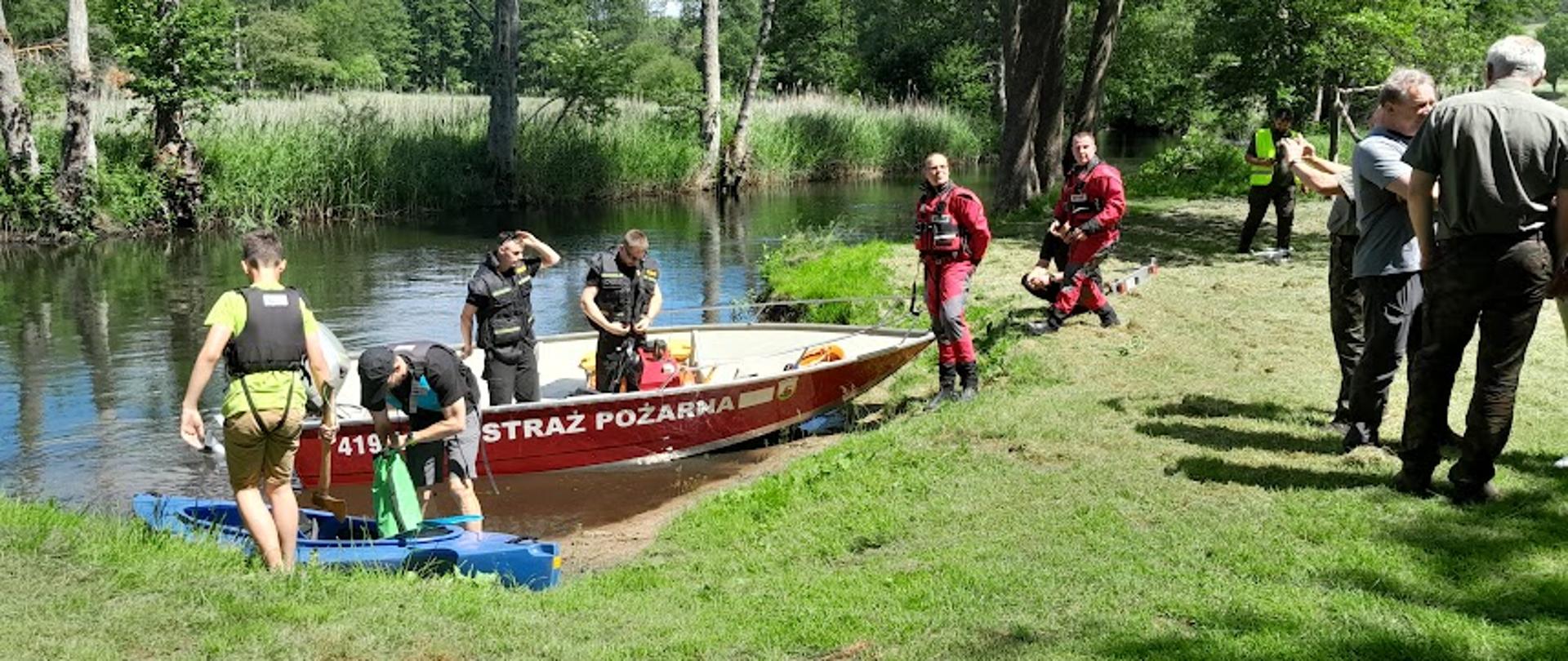 Strażacy wodóją łódkę 