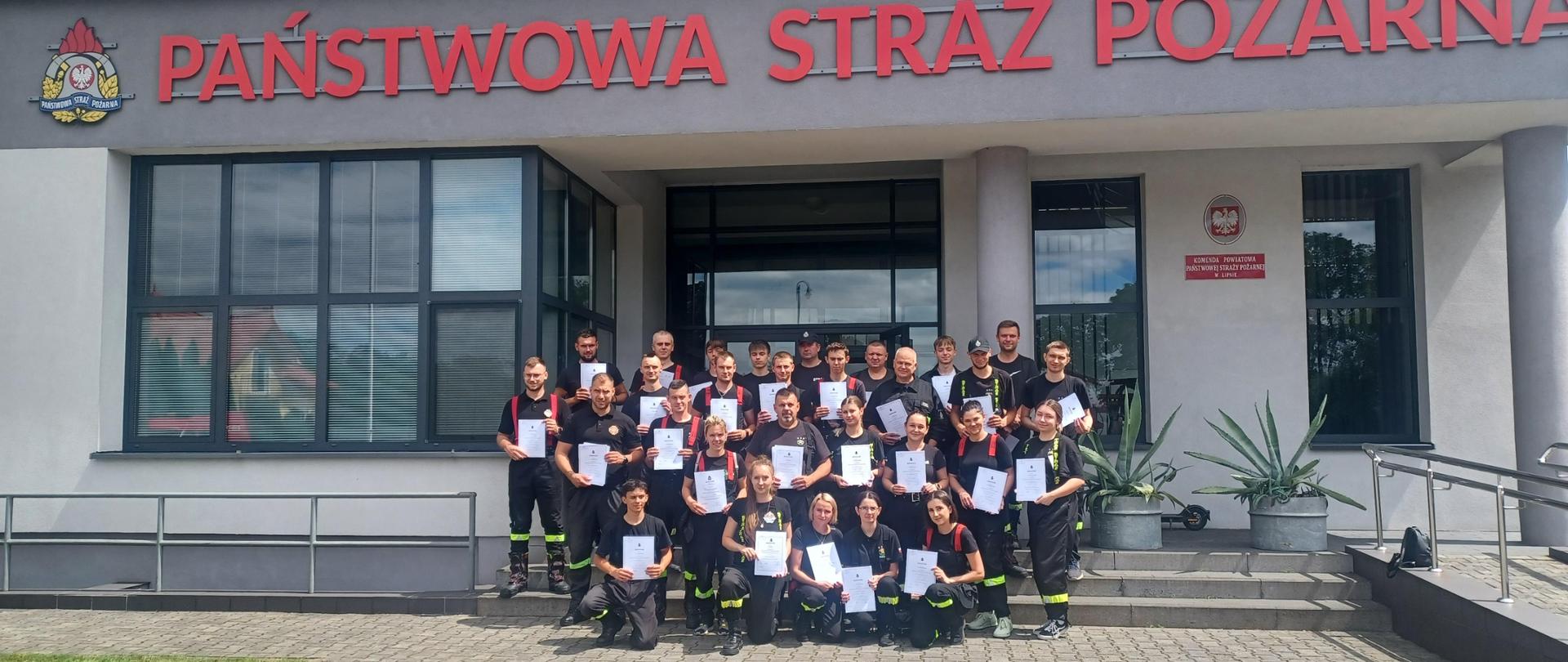 Na zdjęciu grupa strażaków OSP po zdanym egzaminie teoretycznym i praktycznym. Zdjęcie grupowe po rozdaniu zaświadczeń.