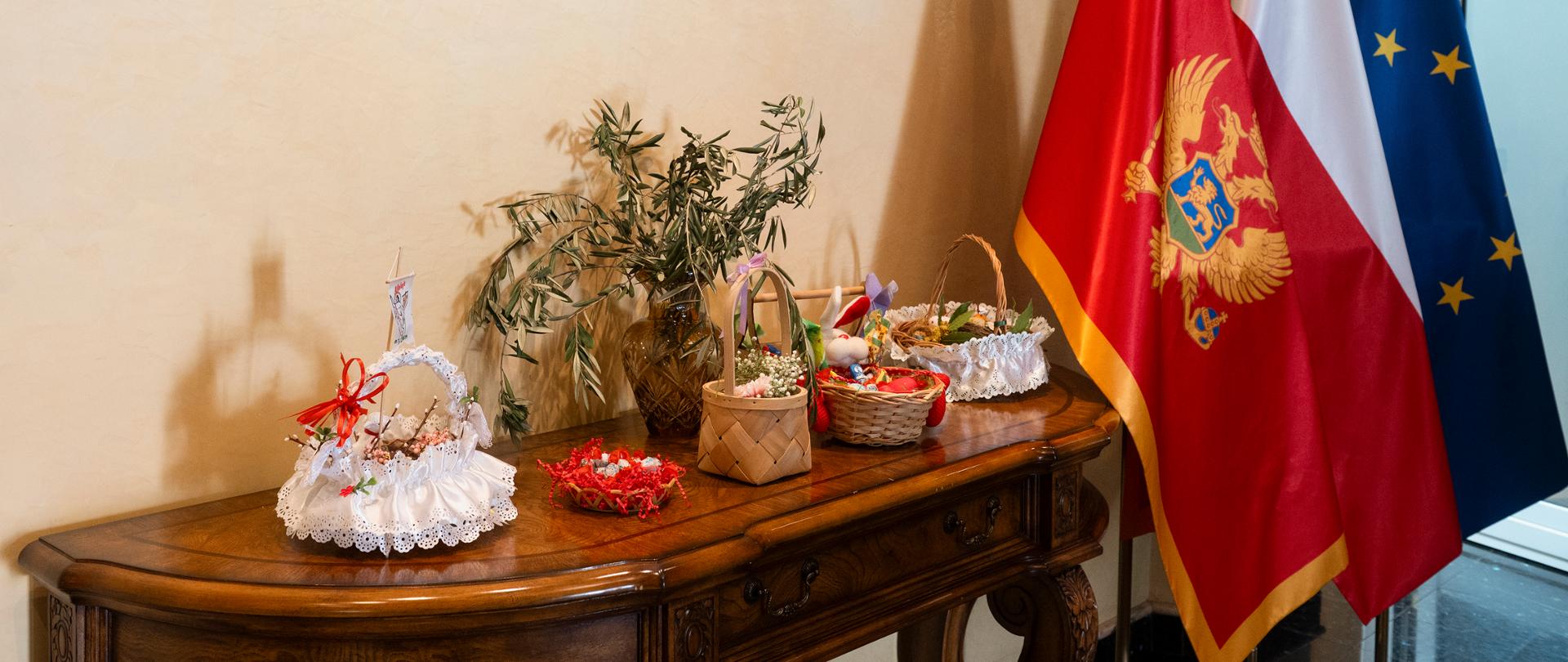 Koszyczki wielkanocne przy fladze Czarnogóry, RP i UE