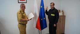 Zdjęcie przedstawia od lewej Komendanta wyczytującego rotę ślubowania i strażaka składającego ślubowanie 