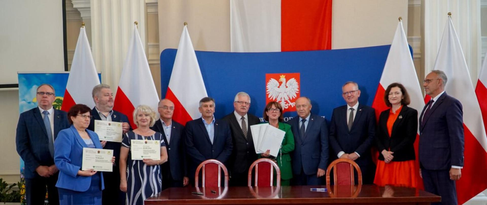 Grupa osób w sali kolumnowej Podkarpackiego Urzędu Wojewódzkiego w Rzeszowie