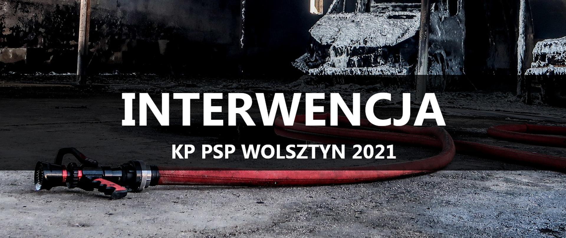 Prądownica z wężem, z tyłu spalone samochody, napis INTERWENCJA KP PSP WOLSZTYN 2021.