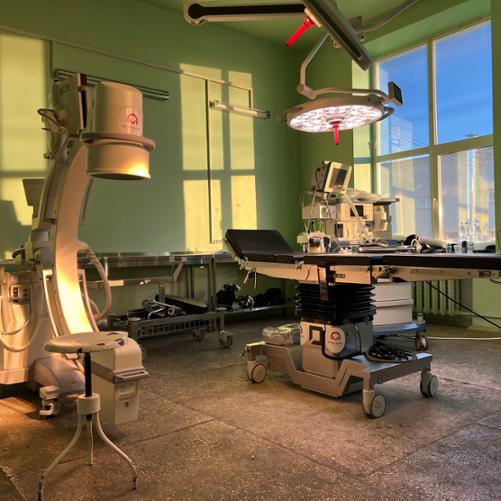 Sala operacyjna z widocznym stołem operacyjnym oznakowanym logo Polska pomoc