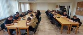 Na zdjęciu widoczni uczestnicy szkolenia siedzący w ławkach w trakcie pisania egzaminu końcowego.