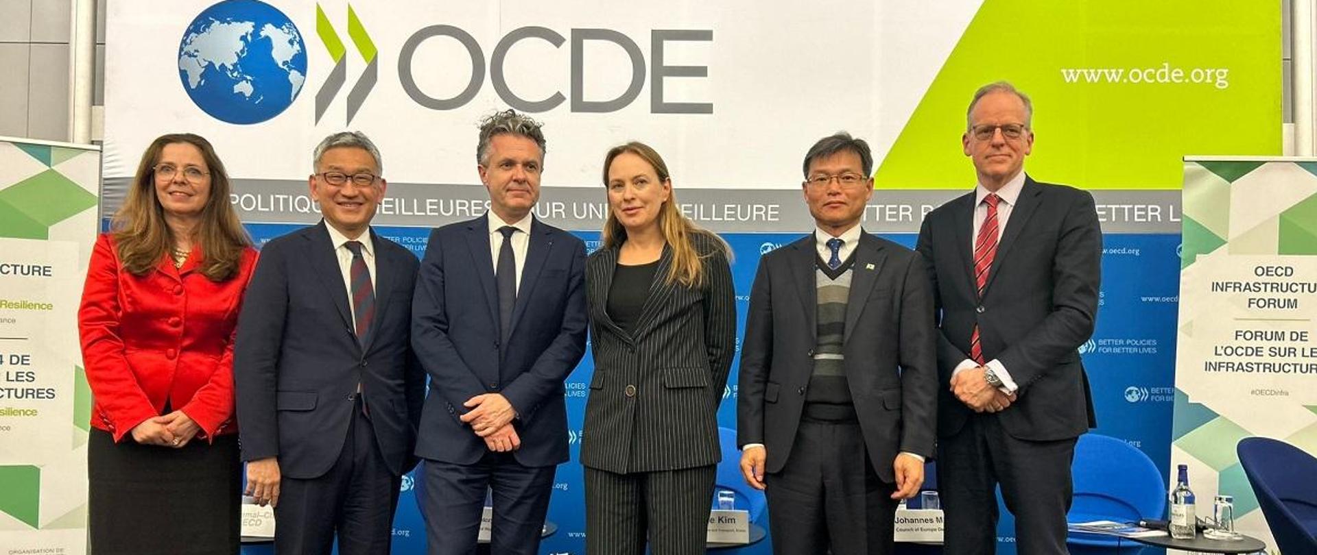 Minister funduszy i polityki regionalnej Katarzyna Pełczyńska-Nałęcz stoi, na tle baneru OECD, po jej prawej stronie stoi Minister Spójności Terytorialnej i Transformacji Ekologicznej Francji Christopherem Béchu