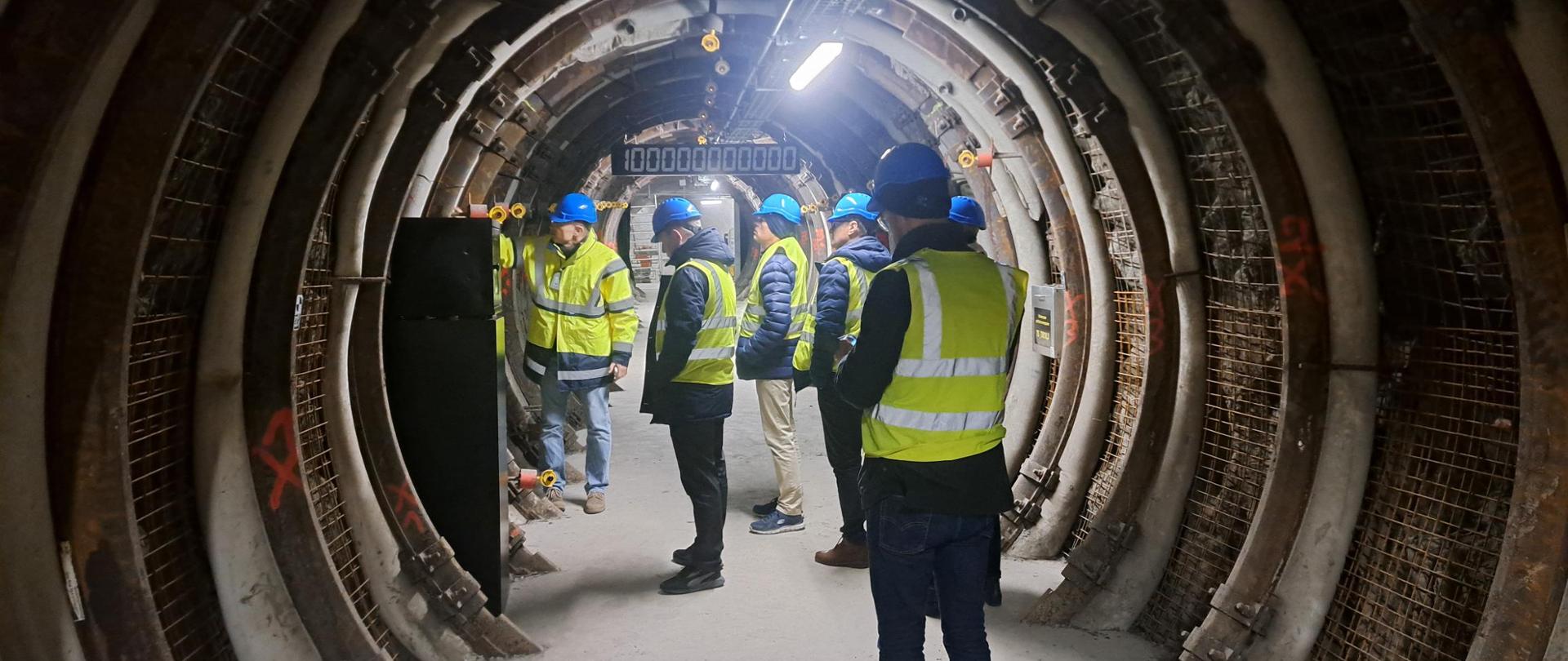 Na zdjęciu widoczne są osoby podczas podczas wizyty w jednym z podziemnych obiektów.