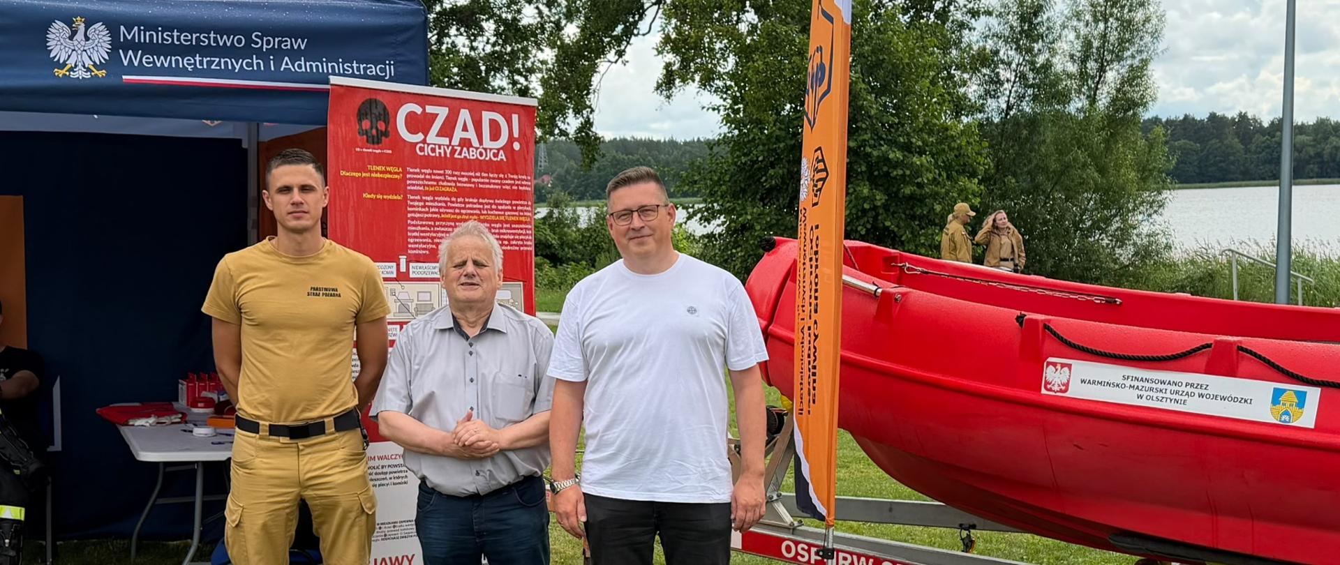 3 mężczyzn, w tym wicewojewoda, pozują do zdjęcia na tle namiotu 