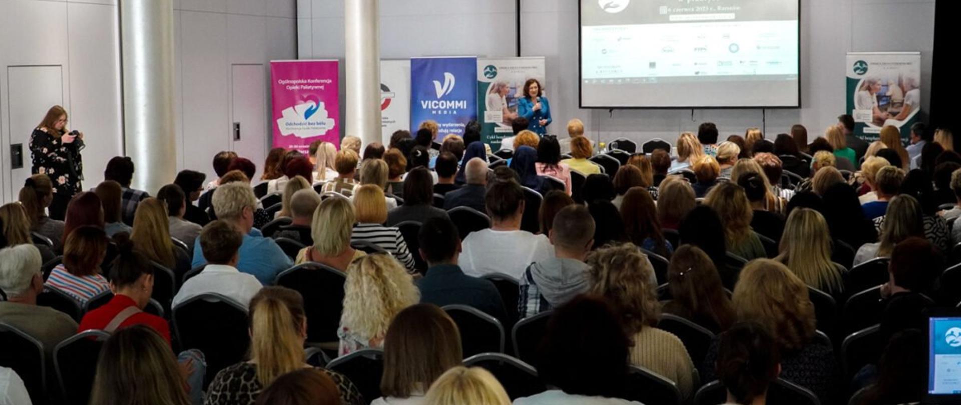 Wojewoda podkarpacki Ewa Leniart zabiera głos podczas konferencji na temat opieki długoterminowej. Na sali konferencyjnej licznie zgromadzeni uczestnicy konferencji