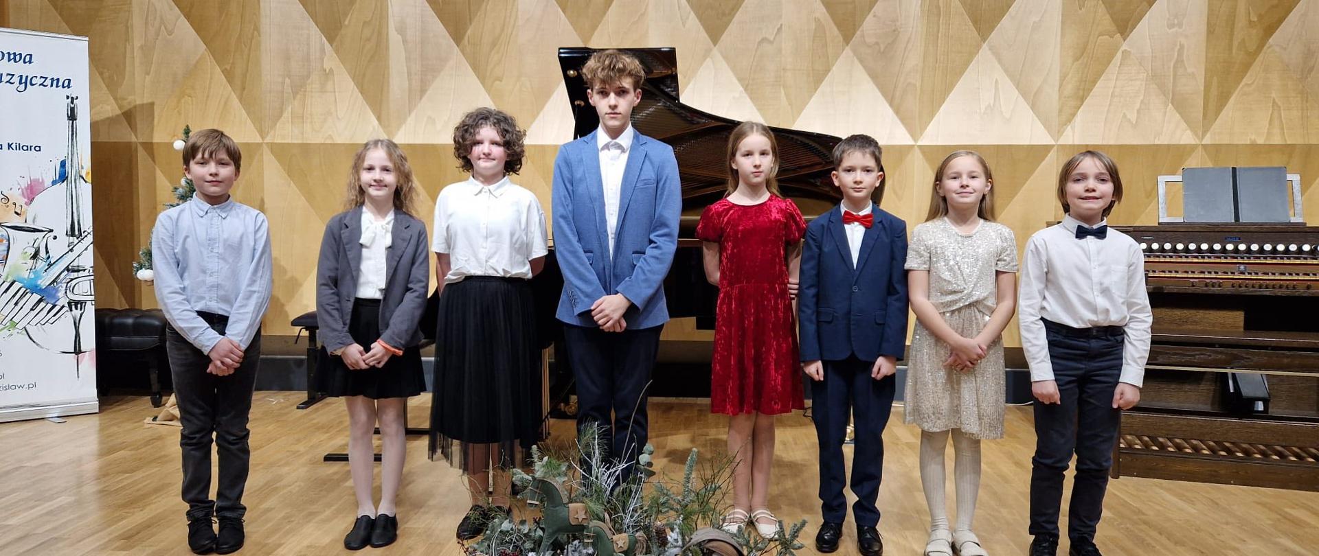 Grupa uczniów na scenie sali koncertowej