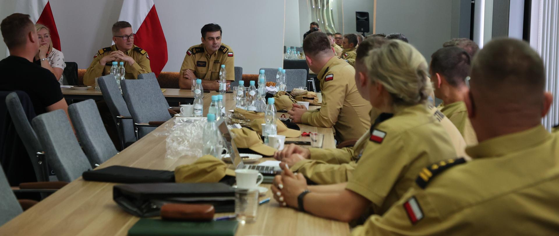 na sali przy stołach siedzą funkcjonariusze i osoby cywilne podczas spotkania Zespołu zadaniowego