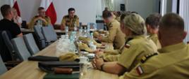 na sali przy stołach siedzą funkcjonariusze i osoby cywilne podczas spotkania Zespołu zadaniowego