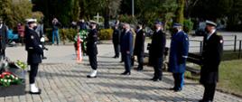 Żołnierz Marynarki Wojennej składa wieniec w asyście wojewody pomorskiego oraz służb mundurowych.