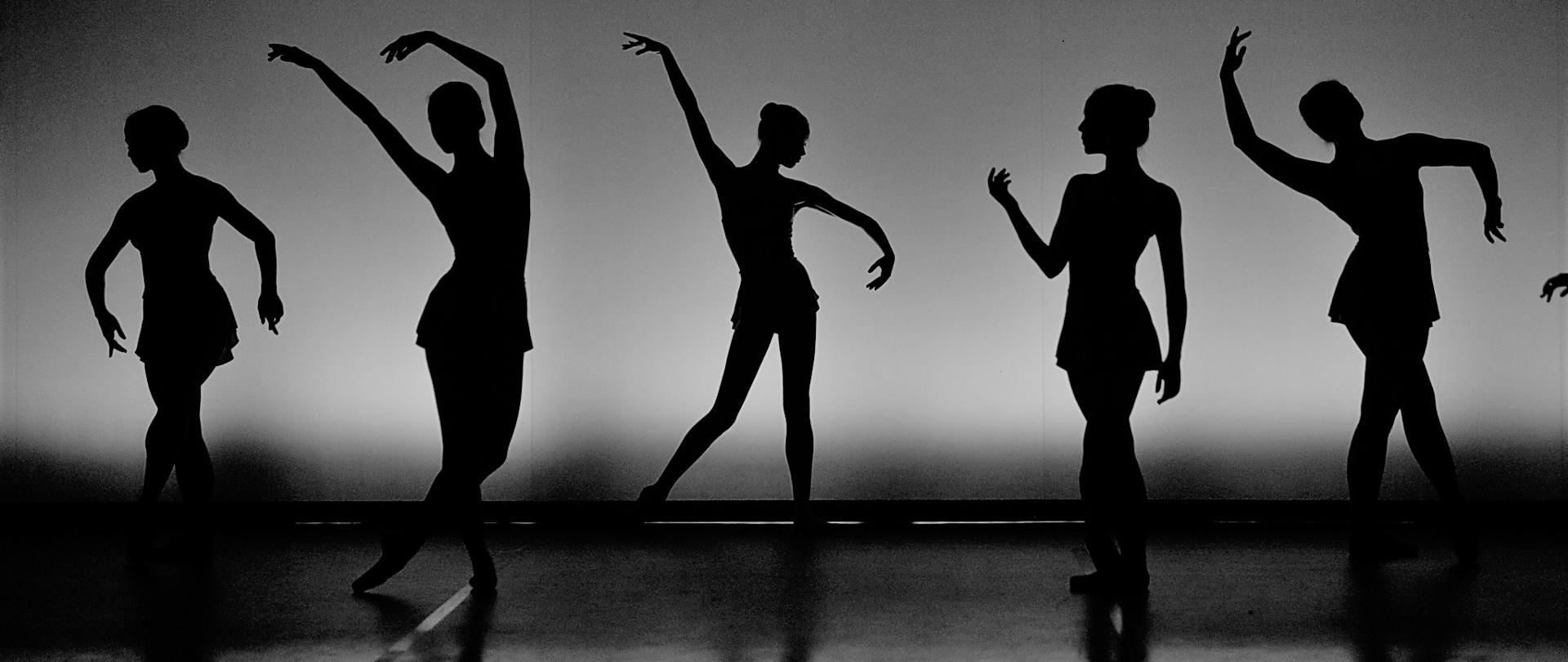 Sylwetki 5 tancerzy na scenie czarnobiałe zdjęcie 